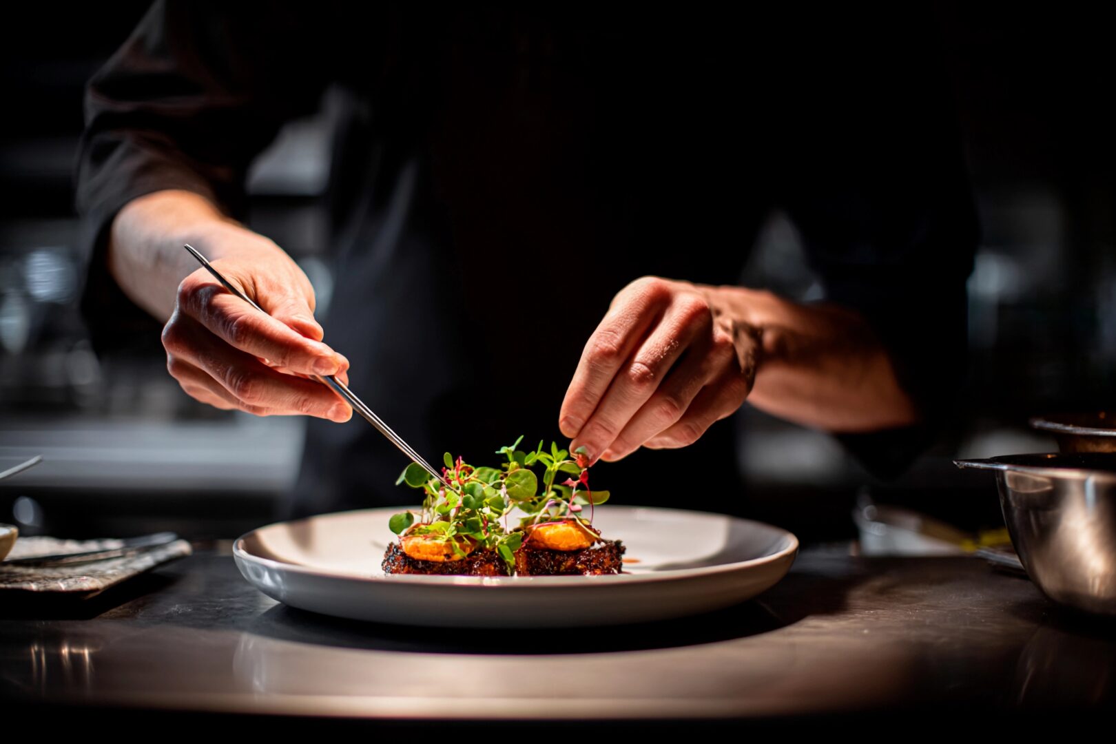 culinary travel tours: In a chic kitchen, a focused chef delicately garnishes a plated dish with fresh herbs and microgreens, showcasing culinary artistry during evening dinner preparation - romantic trips