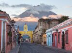 Colonial Architecture and Street Scene during Early Morning Sunrise in Antigua Guatemala with Santa Catalina Arch and Agua Volcano in the Background