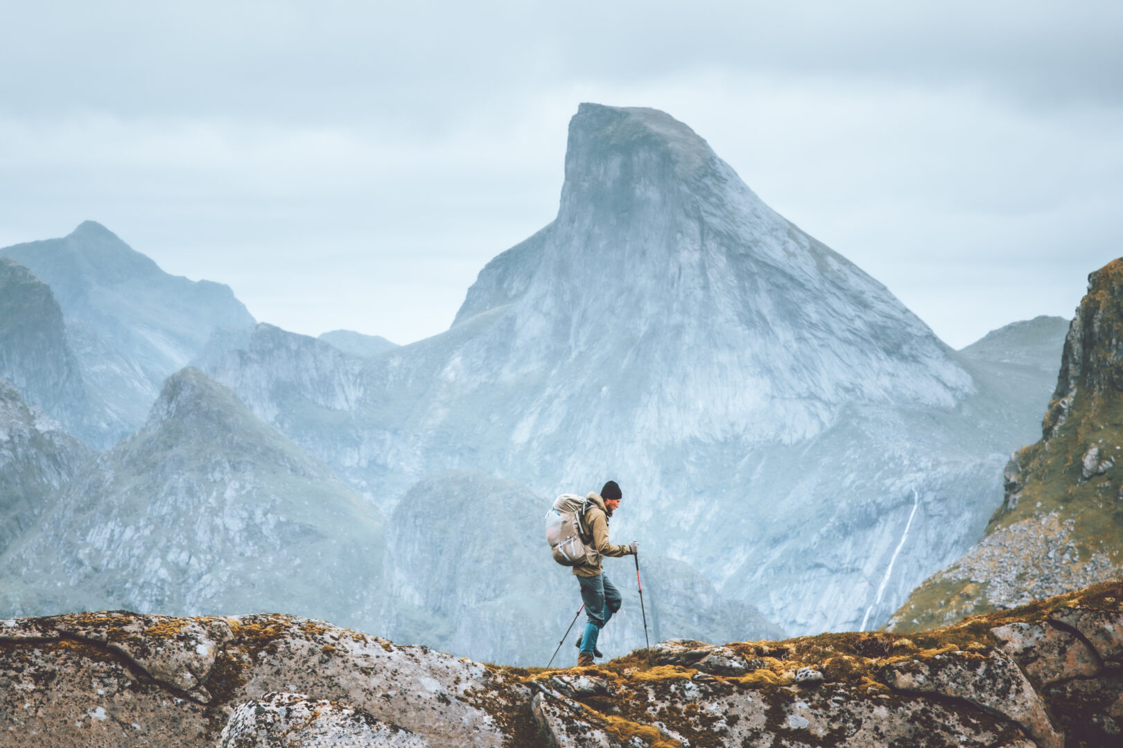 Off the beaten path travel: Man hiking in mountains traveling solo with backpack outdoor active vacations in Norway