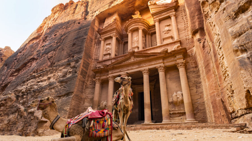 Stunning view of two camels posing in front of the Al Khazneh (The Treasury) in Petra. Al-Khazneh is one of the most elaborate temples in Petra, Jordan.