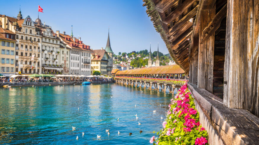 Famous Chapel Bridge in the historic city center of Lucerne, the city's symbol and one of Switzerland's main tourist attractions and views on a sunny day in summer, Canton of Lucerne, Switzerland.