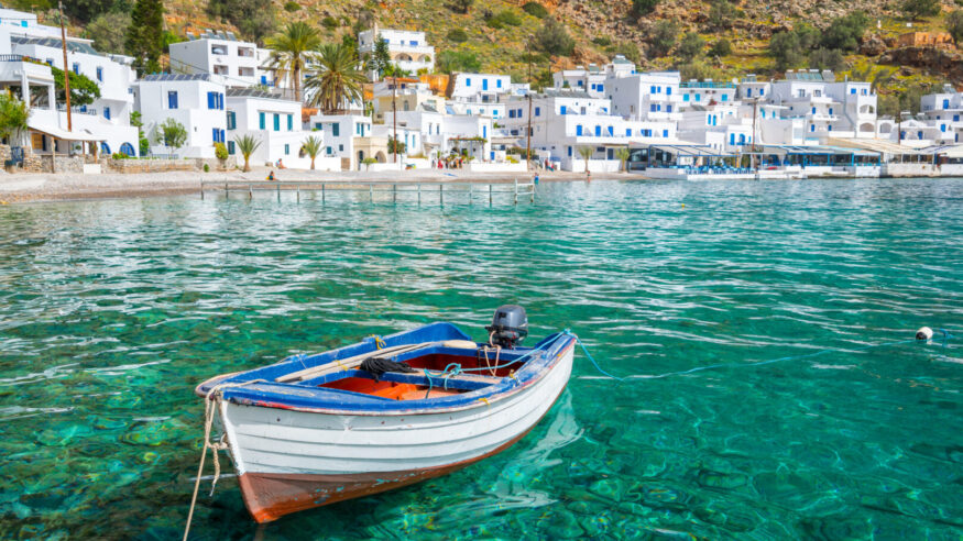 Fishing boat and the scenic village of Loutro in Crete, Greece